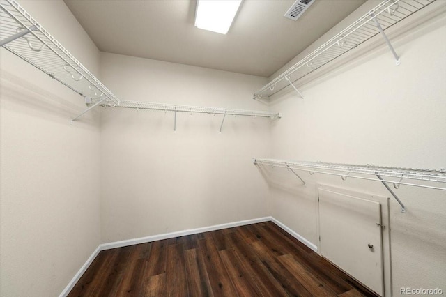 spacious closet featuring dark wood-style flooring and visible vents