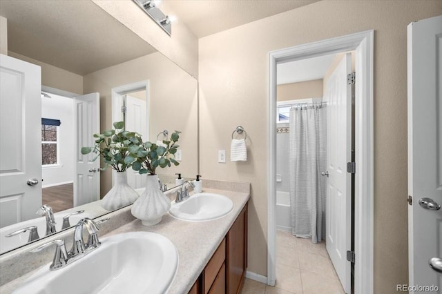 bathroom featuring double vanity, a shower with curtain, tile patterned flooring, and a sink