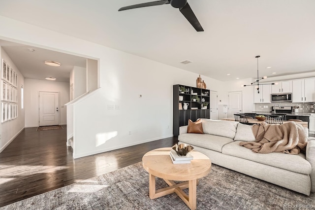 living room featuring sink, dark hardwood / wood-style floors, and ceiling fan