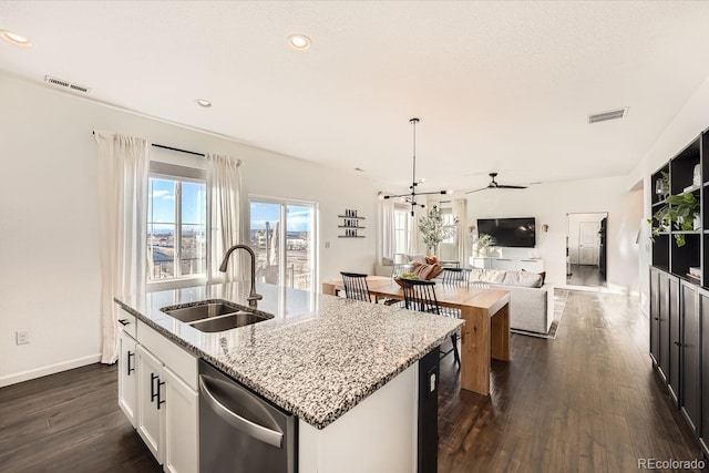 kitchen with sink, white cabinetry, light stone counters, a center island with sink, and stainless steel dishwasher