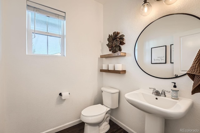 bathroom with wood-type flooring, toilet, and sink