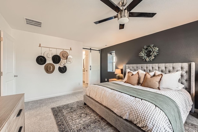 bedroom with a barn door, carpet floors, and ceiling fan