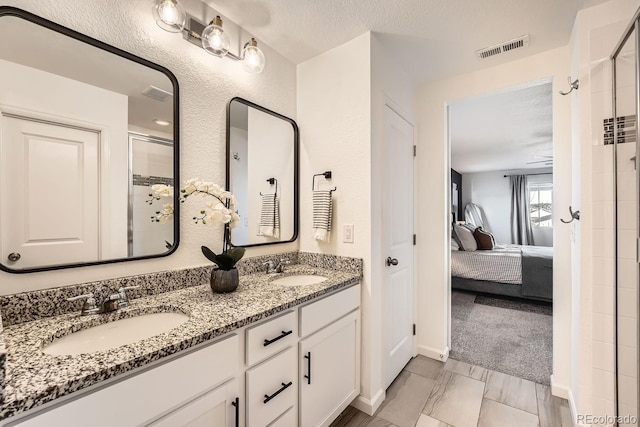 bathroom with vanity, a textured ceiling, and walk in shower