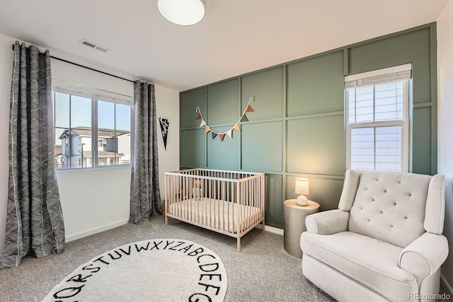 carpeted bedroom featuring a crib