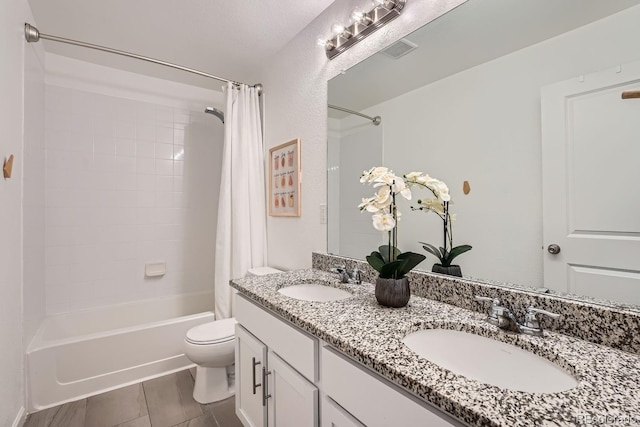 full bathroom with vanity, shower / tub combo, and toilet