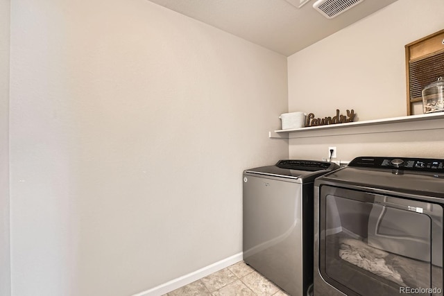 washroom with separate washer and dryer and light tile patterned floors