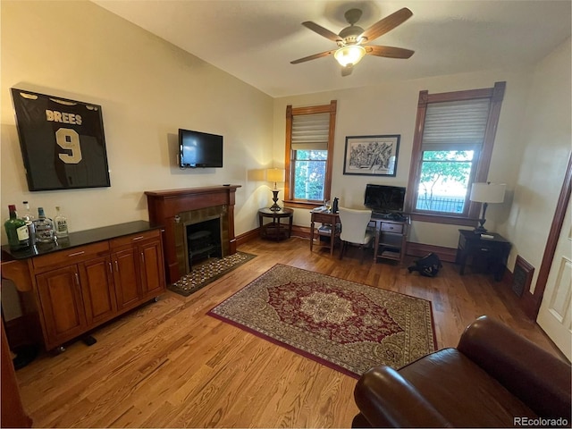 2335 Stout St, Denver, CO 80205 - office featuring light wood-style floors, a ceiling fan, a tiled fireplace, and baseboards