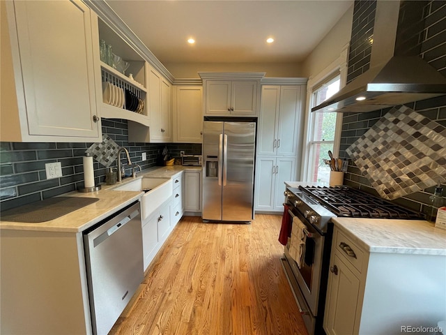 2335 Stout St, Denver, CO 80205 - kitchen with appliances with stainless steel finishes, open shelves, wall chimney range hood, tasteful backsplash, and light wood-style flooring