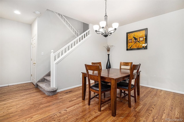 dining area featuring hardwood / wood-style flooring and an inviting chandelier