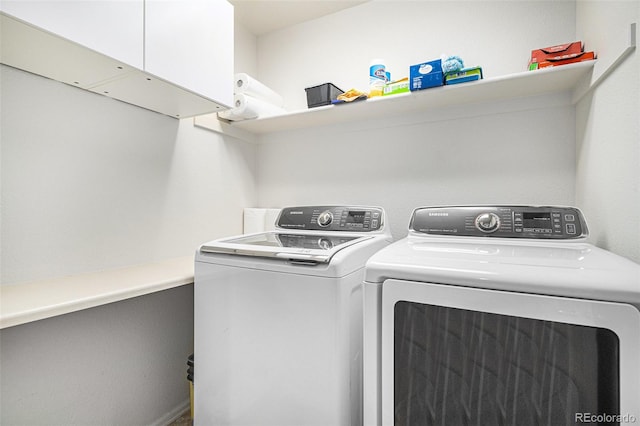 laundry area featuring independent washer and dryer and cabinets