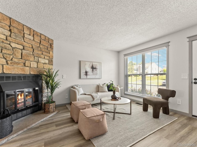 19726 Applewood Ct, Parker, CO 80138 - living room featuring wood finished floors, a textured ceiling, and a fireplace