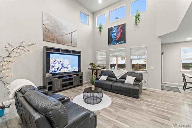 living area with baseboards, plenty of natural light, and wood finished floors