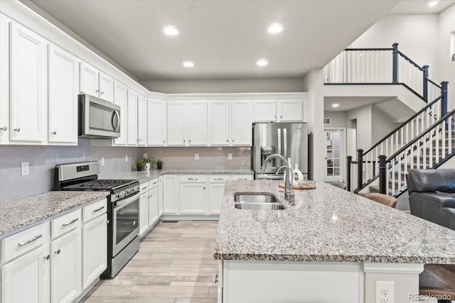 17880 W 94th Dr, Arvada, CO 80007 - kitchen featuring stainless steel appliances, a sink, light wood-style floors, white cabinetry, and recessed lighting