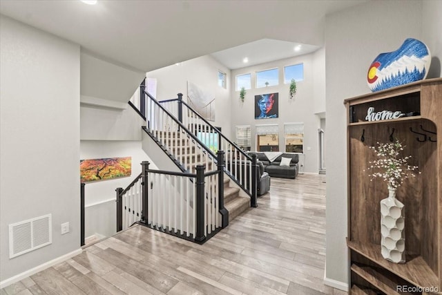 17880 W 94th Dr, Arvada, CO 80007 - staircase featuring wood finished floors, recessed lighting, baseboards, and a towering ceiling
