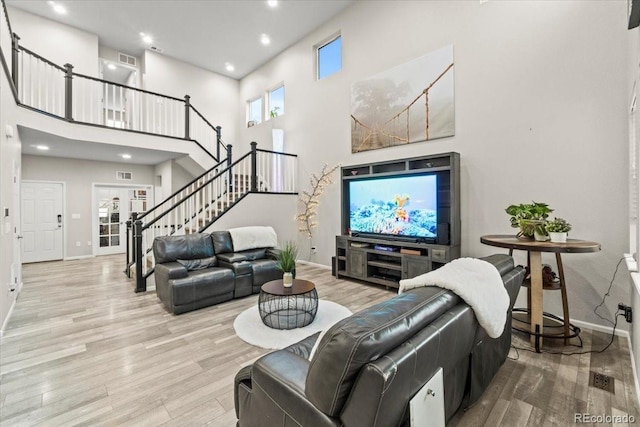 17880 W 94th Dr, Arvada, CO 80007 - living room featuring baseboards, wood finished floors, stairs, a towering ceiling, and recessed lighting