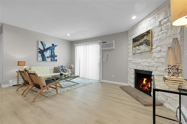 10150 Virginia Ave Unit 103, Denver, CO 80247 - living area featuring a baseboard radiator, wood finished floors, a stone fireplace, recessed lighting, and a wall mounted air conditioner