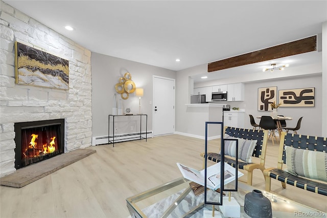 10150 Virginia Ave Unit 103, Denver, CO 80247 - living room featuring light wood finished floors, a baseboard radiator, beamed ceiling, a fireplace, and recessed lighting
