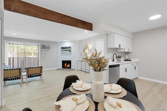 10150 Virginia Ave Unit 103, Denver, CO 80247 - dining area featuring light wood finished floors, a wall mounted air conditioner, a fireplace, and recessed lighting