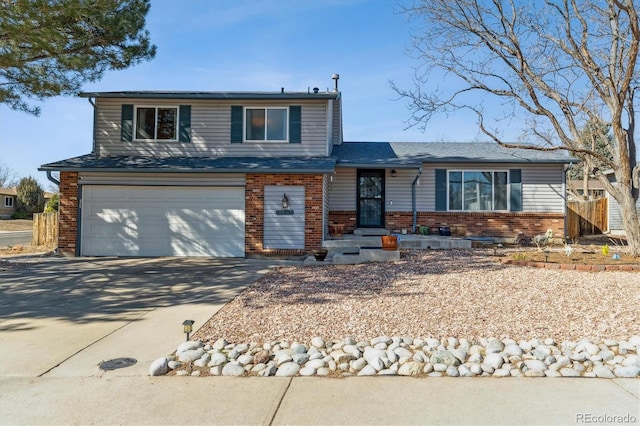 split level home with a garage, concrete driveway, brick siding, and fence