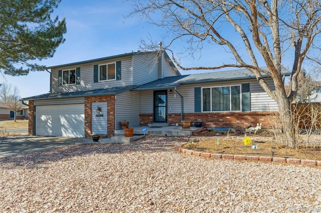 tri-level home with driveway, brick siding, and an attached garage