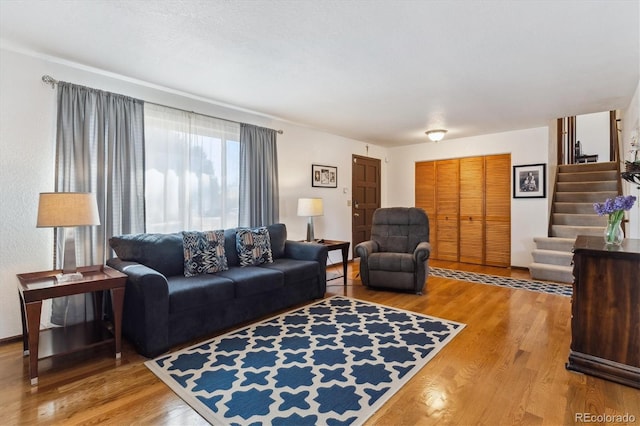 living room with stairway and wood finished floors