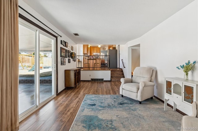 sitting room featuring stairway, wood finished floors, visible vents, and baseboards