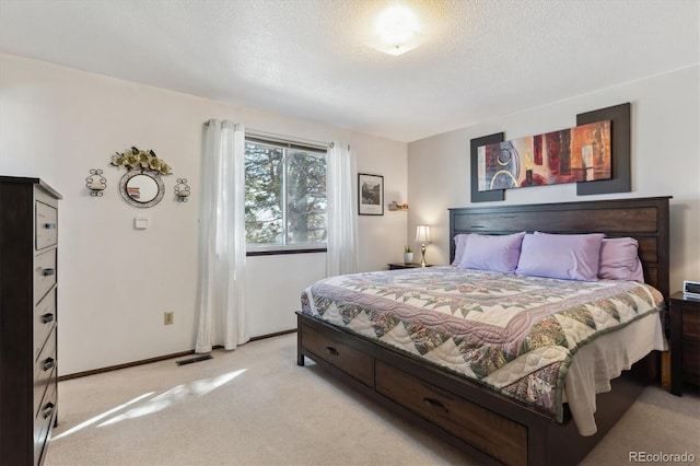 bedroom featuring baseboards, visible vents, light carpet, and a textured ceiling