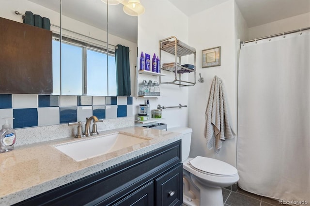 bathroom featuring tile patterned flooring, backsplash, vanity, and toilet