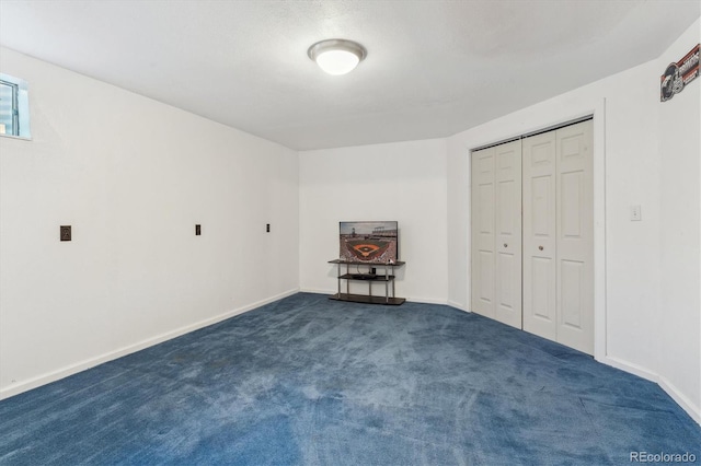 unfurnished bedroom featuring dark colored carpet, a closet, and baseboards