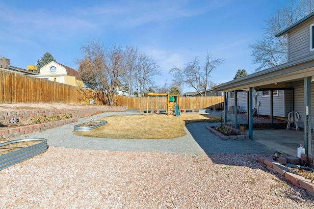 view of yard featuring a fenced backyard, a playground, and a patio