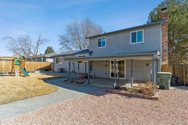 rear view of property with central AC unit, a chimney, a patio area, and fence