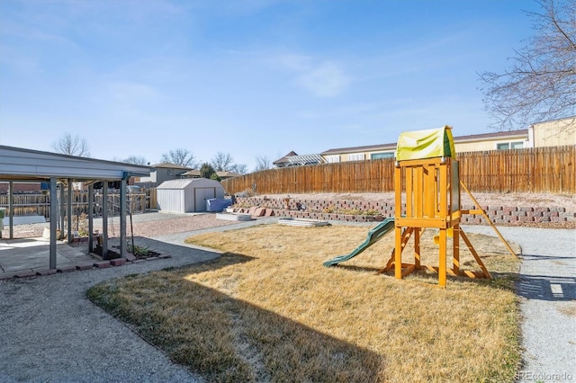 view of yard featuring an outbuilding, a playground, a patio area, a shed, and a fenced backyard