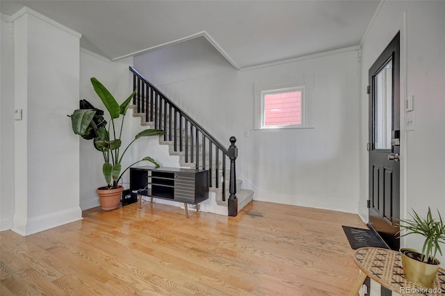 entrance foyer featuring ornamental molding and light hardwood / wood-style flooring