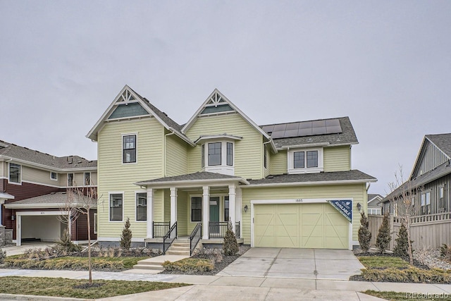 view of front of home featuring a garage, a porch, and solar panels