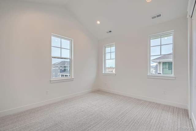 spare room with vaulted ceiling and carpet