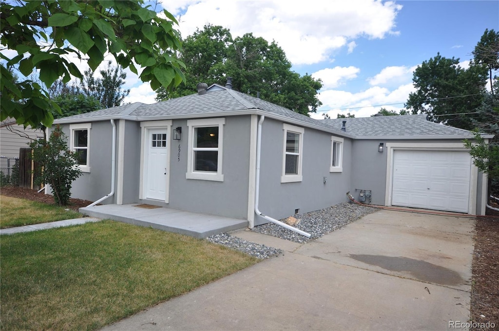 ranch-style home with a garage and a front lawn