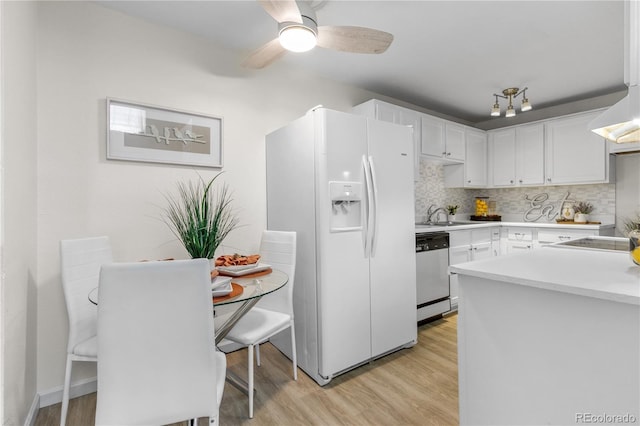 kitchen featuring light countertops, white cabinets, white refrigerator with ice dispenser, dishwasher, and light wood-type flooring