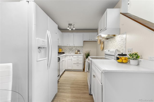 kitchen with white appliances, light wood finished floors, white cabinets, under cabinet range hood, and backsplash