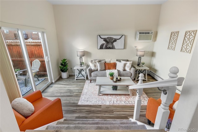 living area featuring a wall mounted air conditioner, stairway, baseboards, and wood finished floors