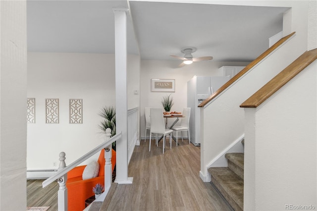 interior space featuring stairway, a baseboard radiator, and wood finished floors