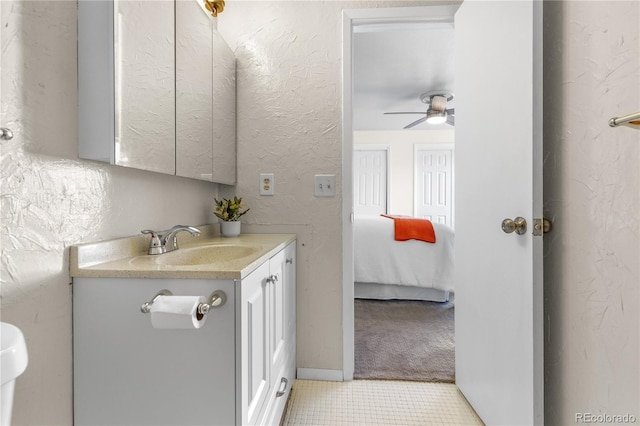 bathroom with vanity, a textured wall, and ceiling fan