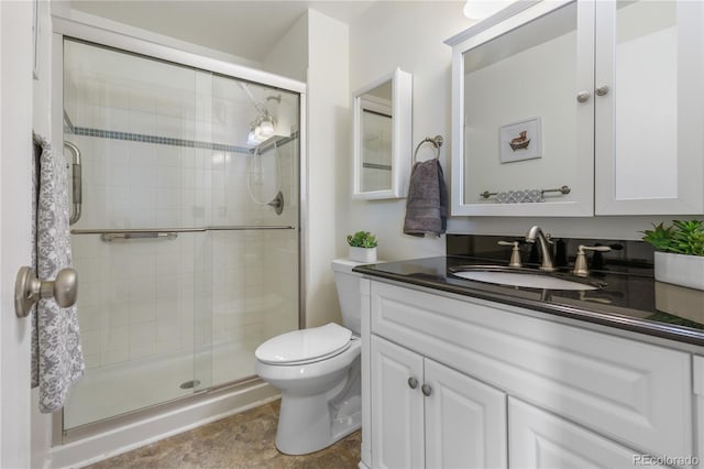 bathroom featuring vanity, toilet, and a stall shower