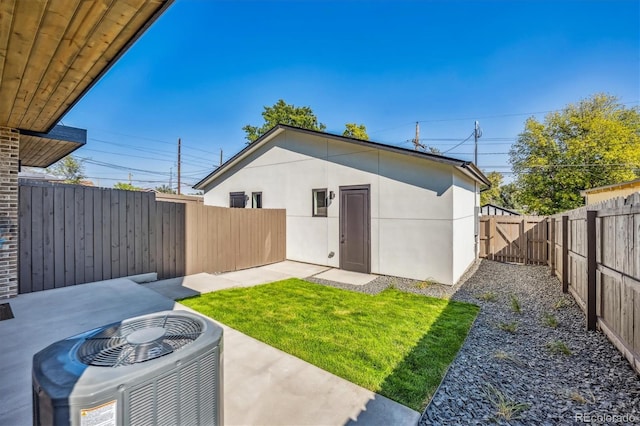 rear view of property with a patio, a yard, and cooling unit