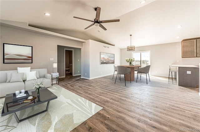 living room featuring ceiling fan, lofted ceiling, and wood-type flooring