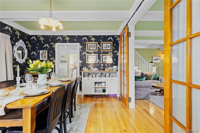 7835 Valley View St, Louviers, CO 80131 - dining space with light wood-style flooring, stairs, wallpapered walls, a chandelier, and beam ceiling