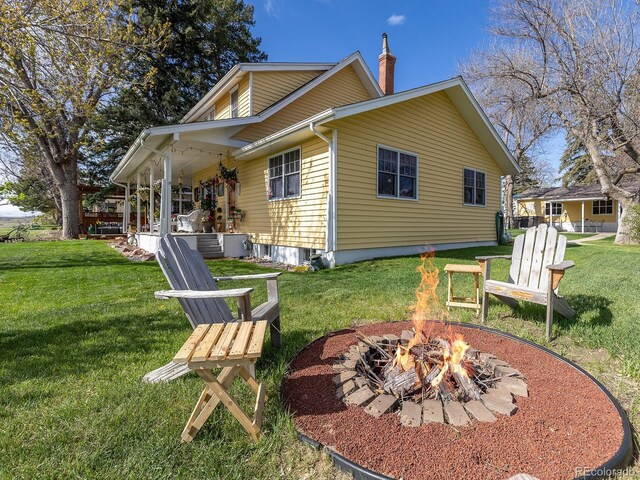 7835 Valley View St, Louviers, CO 80131 - back of house featuring a fire pit, a yard, and a chimney