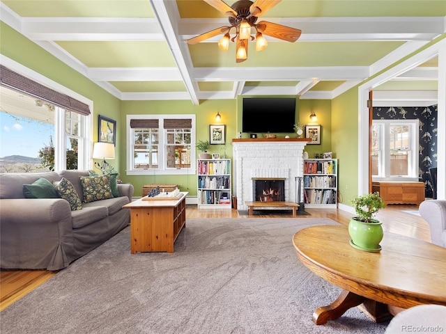 7835 Valley View St, Louviers, CO 80131 - living area with coffered ceiling, a brick fireplace, beam ceiling, a ceiling fan, and a baseboard radiator