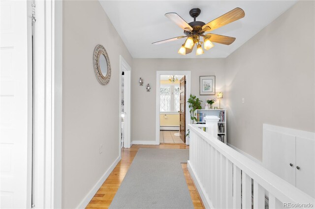 7835 Valley View St, Louviers, CO 80131 - hall featuring a baseboard heating unit, baseboards, and light wood-style flooring