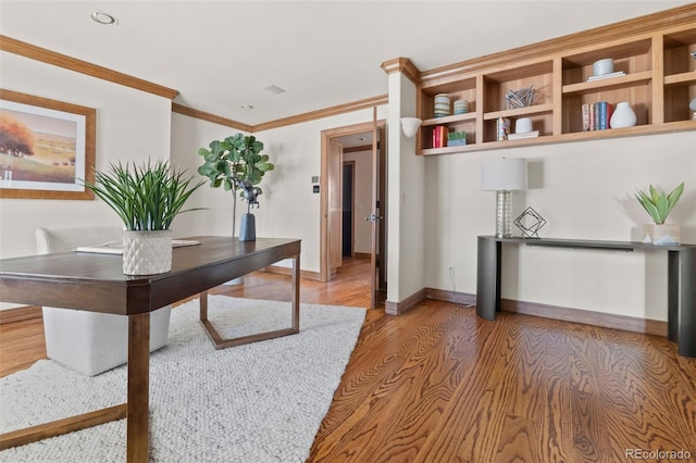 office area with light wood-type flooring, baseboards, and ornamental molding