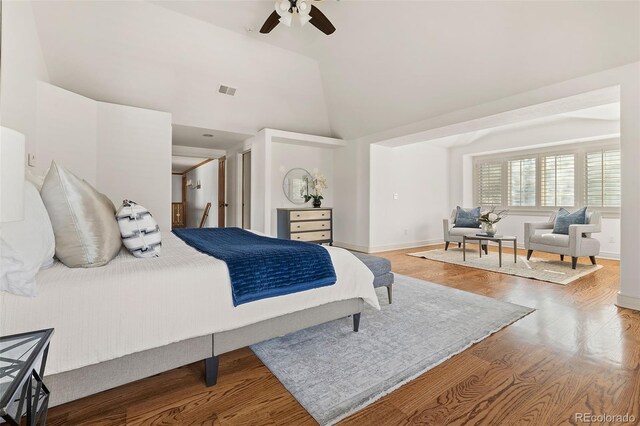 bedroom featuring high vaulted ceiling, wood finished floors, a ceiling fan, and baseboards